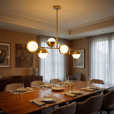 Mesa de comedor residencial iluminada por la estructura dorada de la lampara Nova.