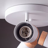 Vista interior del cuerpo tubular blanco con recubrimiento de madera para bombillas dicroicas.