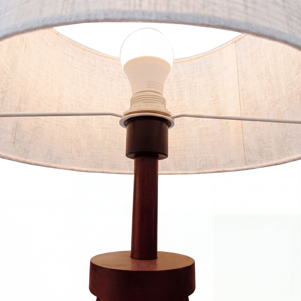 Detalle técnico de ensamble superior de madera noble y soporte para bombilla de rosca estándar.