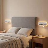 Dos apliques LED instalados simétricamente en cabecero de cama de hotel.