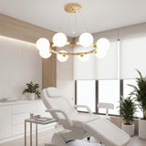Ambiente de consultorio o spa con mobiliario blanco y la lampara Collier Gold aportando un diseño limpio.