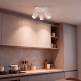 Plafón triple de sobreponer proporcionando luz directa e intensa sobre encimera de cocina.