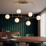 Lampara de techo sobre mesa de comedor de madera con fondo de pared acustica verde.