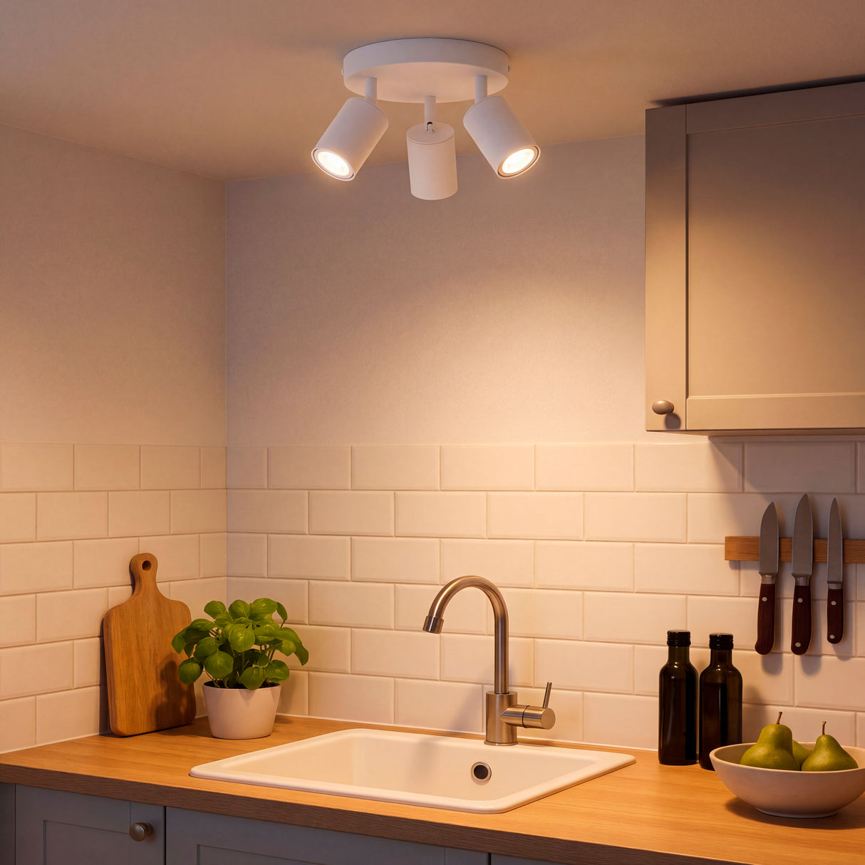 Punto de luz cenital con tres spots orientables aportando alta eficiencia lumínica en cocina moderna.