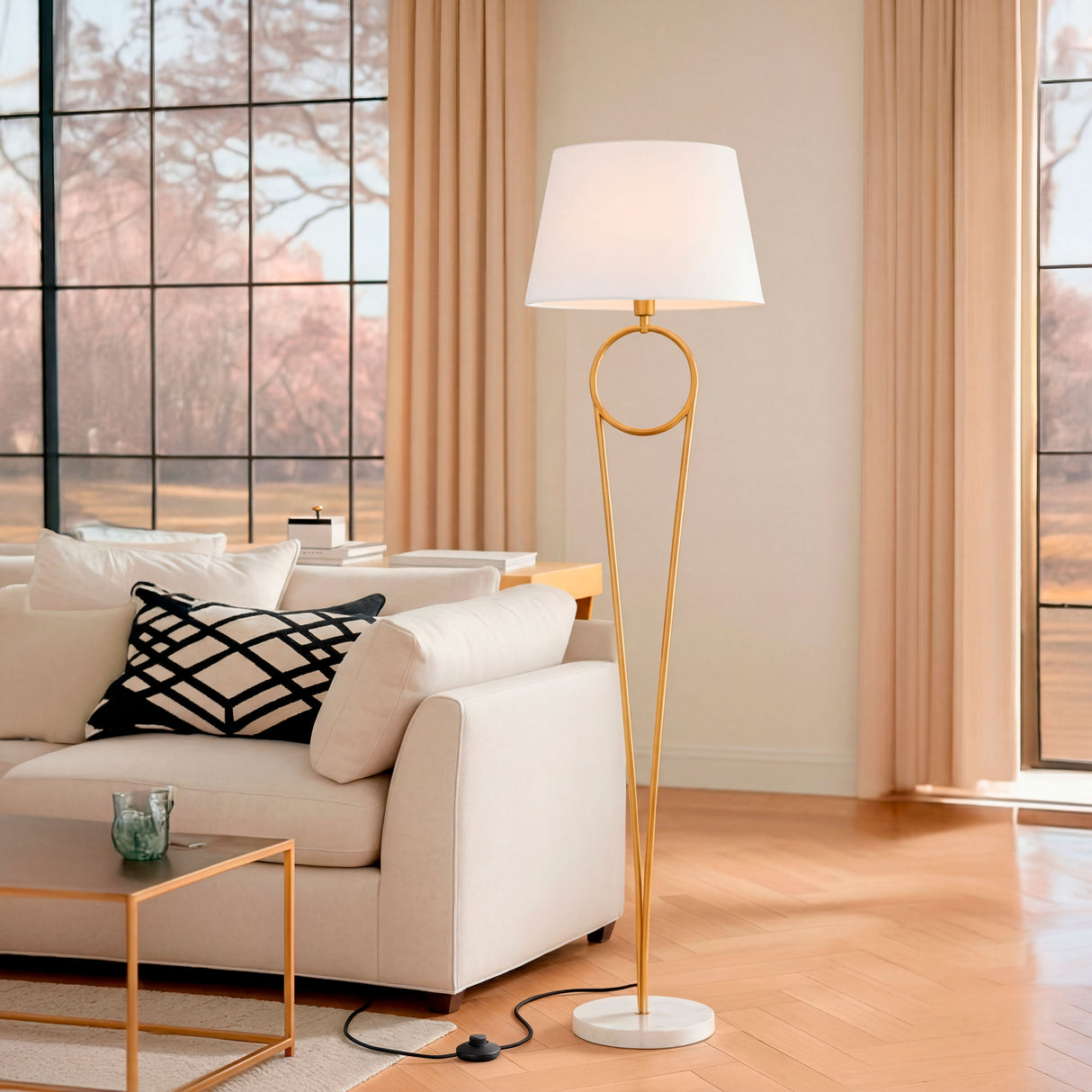 Lámpara Olinda junto a sofá blanco en una sala de estar con vistas al jardín exterior.