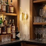 Iluminacion decorativa dorada modelo Vortex instalada en una zona de bar o barra de licores.