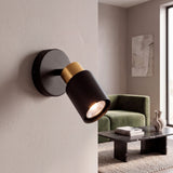 Foco de pared con luz cálida apuntando hacia un ambiente de estar para un diseño minimalista y relajante.