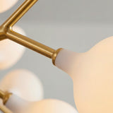 Detalle del acabado dorado y la esfera de vidrio opalino de la lampara Nativa Gold.