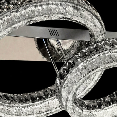 Primer plano de anillos con textura de cristal tallado y estructura metálica plateada.