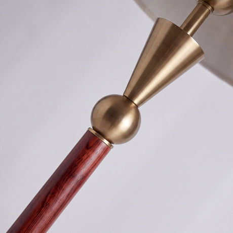 Detalle técnico de junta metálica dorada y cuerpo cilíndrico de madera con acabados premium.