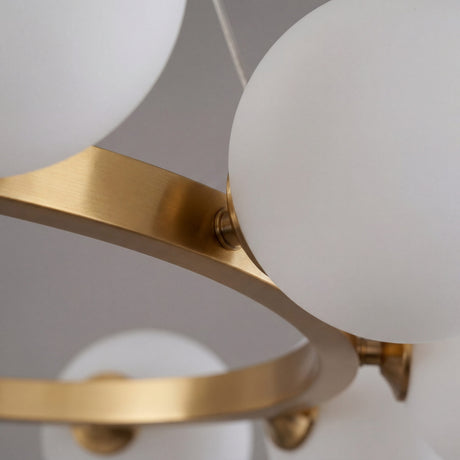 Primer plano del acabado en oro satinado y la union con el globo de vidrio blanco opalizado de la lampara Collier.