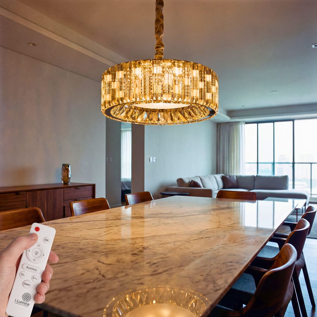Lámpara de techo sobre mesa de madera en salón de concepto abierto con luz ambiental regulable.
