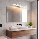 Aplique cromado sobre mueble de baño flotante, proporcionando luz clara y funcional.