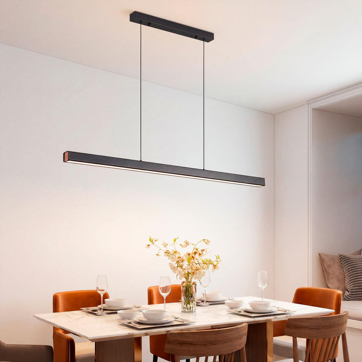 Punto de luz minimalista sobre mesa de comedor redonda en estancia de diseño limpio.