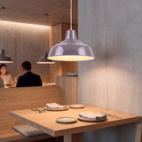 Iluminación focal directa que realza las texturas de madera en un rincón comedor de diseño minimalista.