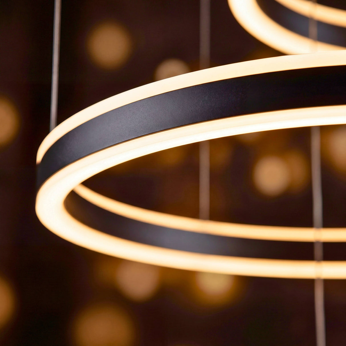 Detalle en primer plano de los aros metálicos con difusor de luz continua y perfilería minimalista premium.