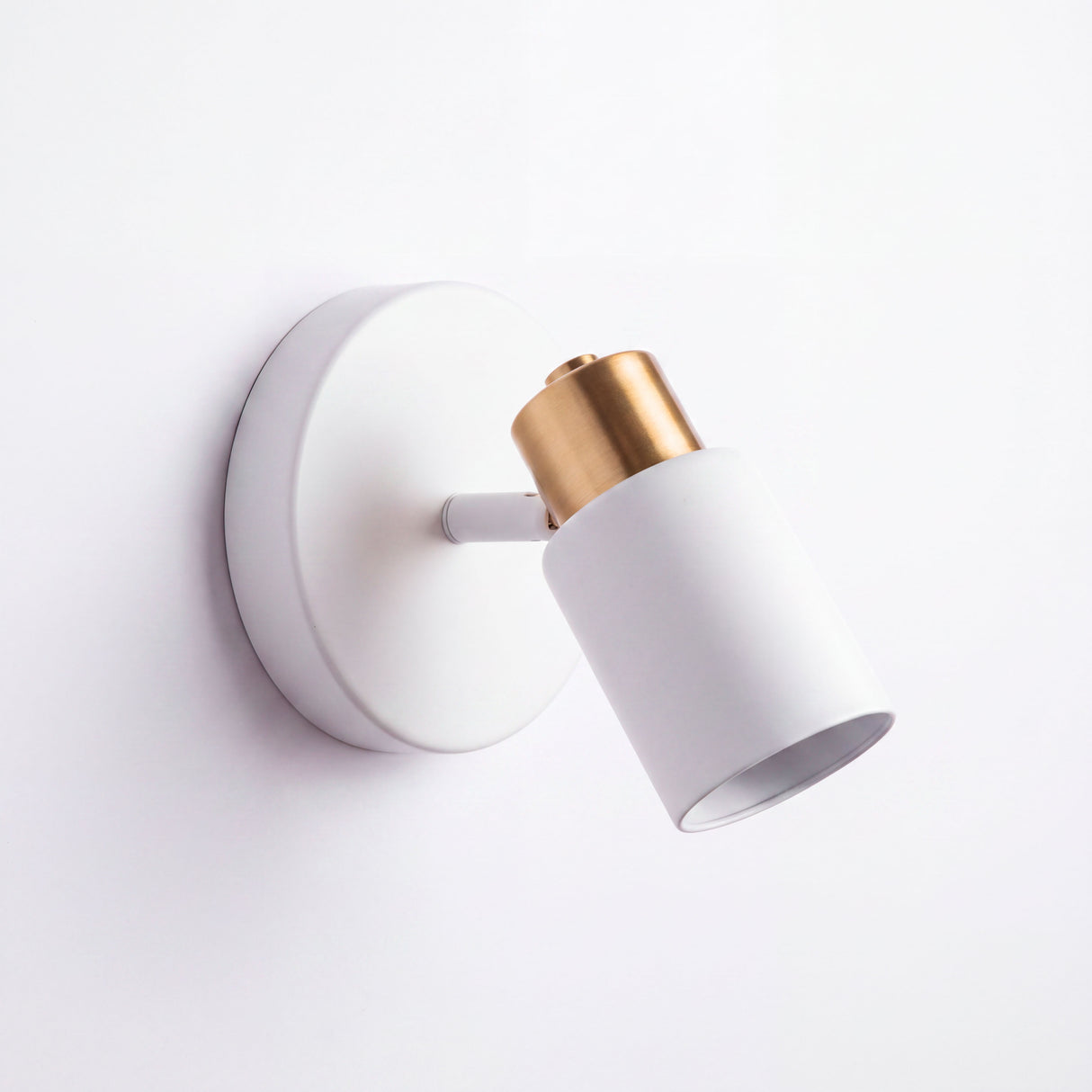 Estructura orientable compacta montada en muro de diseño minimalista para iluminación de soporte.
