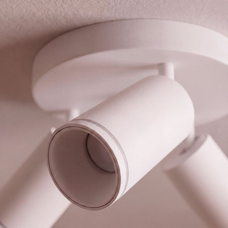 Detalle de cabezal orientable sobreponer en blanco mate para espacios de arquitectura contemporánea.