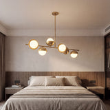 Lampara lineal Nova Gold como pieza central de diseño en un dormitorio principal.