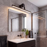 Iluminación técnica integrada sobre lavabo moderno en cuarto de baño con azulejos grises texturizados.