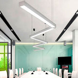 Luminaria geométrica suspendida de forma estable en sala de reuniones de arquitectura contemporánea.