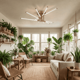 Integración de luminaria dorada en salón con abundante vegetación y luz suave.