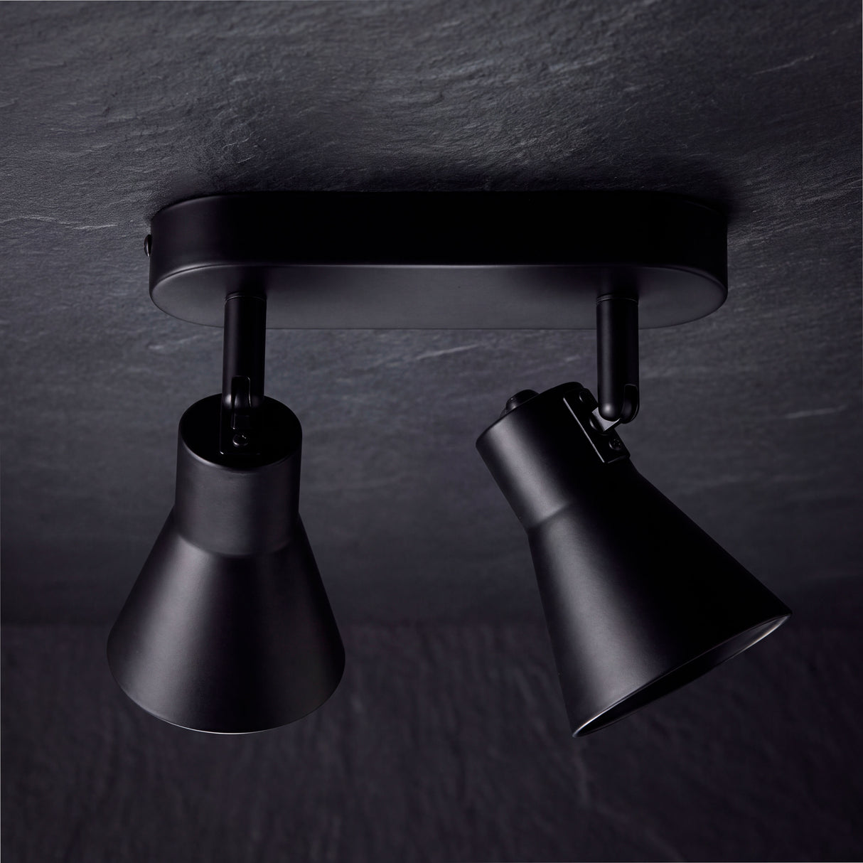 Estructura compacta en aluminio negro mate con articulación giratoria de alta eficiencia lumínica.