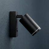 Luminaria de acento para pared en acabado negro mate con cabezal cilíndrico orientable.