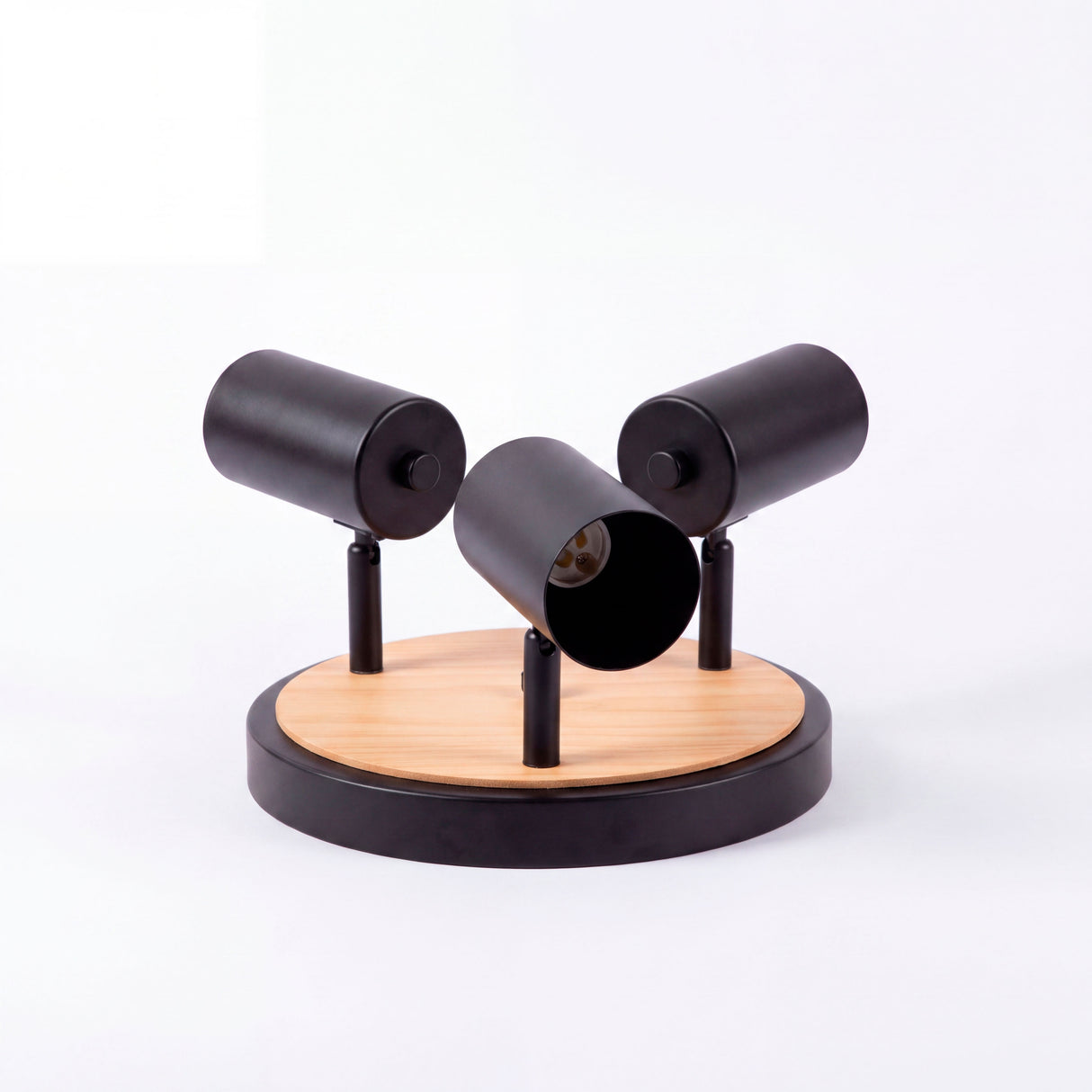 Muestra de catálogo de luminaria triple en negro y madera exenta sobre superficie neutra.