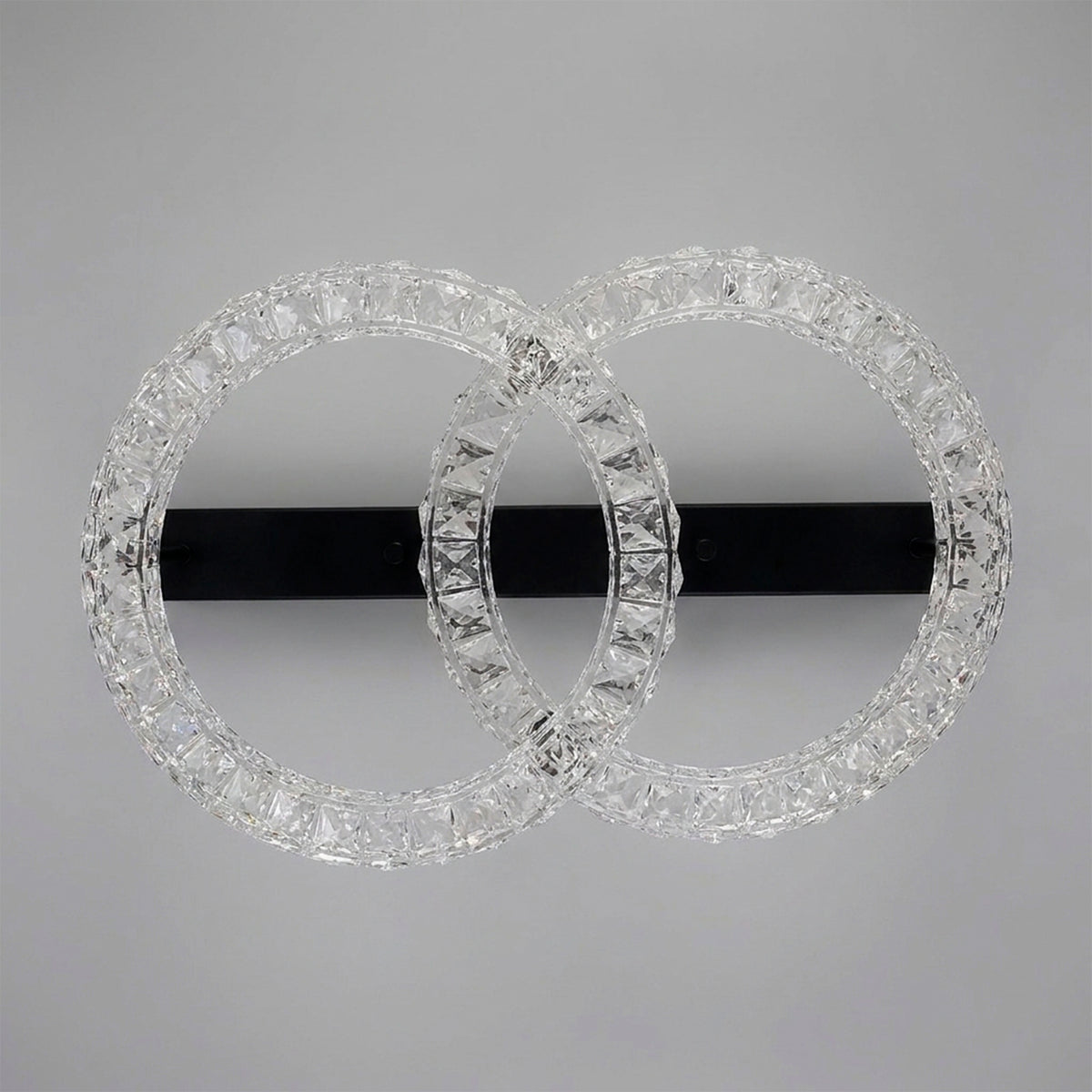Estructura concéntrica de sobreponer en acabado negro mate con aros difusores de textura brillante.