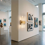 Galeria de arte con iluminacion de pared moderna que resalta cuadros y esculturas.