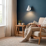 Haz luminoso directo orientable sobre rincón de lectura que favorece la ergonomía y la relajación.