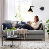 Haz luminoso directo orientable sobre rincón de lectura que promueve la ergonomía y la relajación.
