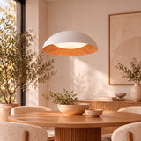 Haz focalizado para área de comedor moderno integrando texturas orgánicas y confort óptico en arquitectura de interiores.