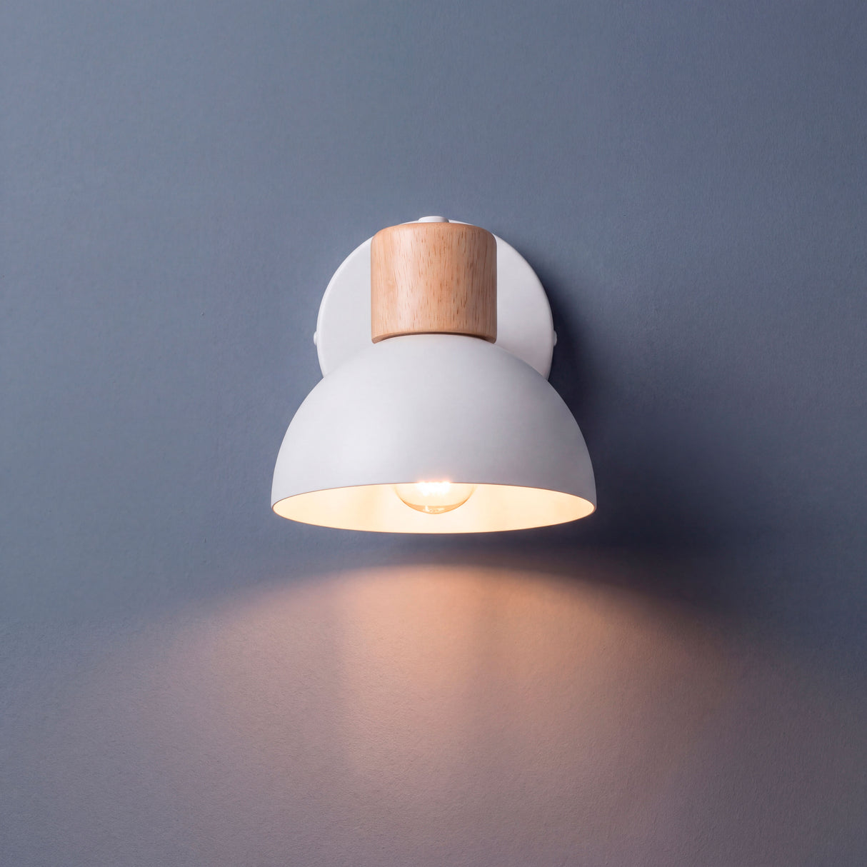 Proyección de haz de luz cálida sobre superficie vertical en ambiente de diseño minimalista.