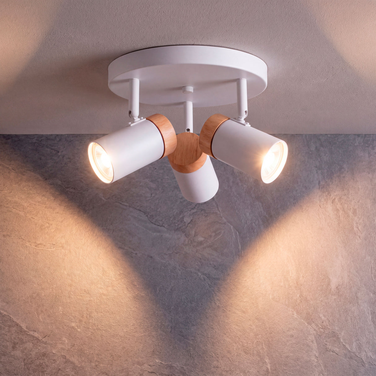 Proyección simétrica de haces de luz cálida sobre superficie plana con diseño de acento.