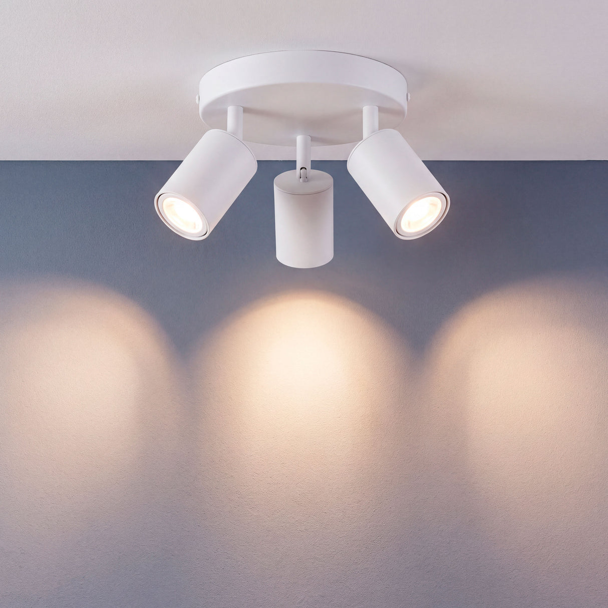 Proyección de haces de luz simétricos sobre pared neutra de estilo minimalista en estancia amplia.