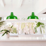 Par de luminarias de suspensión de estilo minimalista instaladas en simetría sobre isla de cocina moderna.
