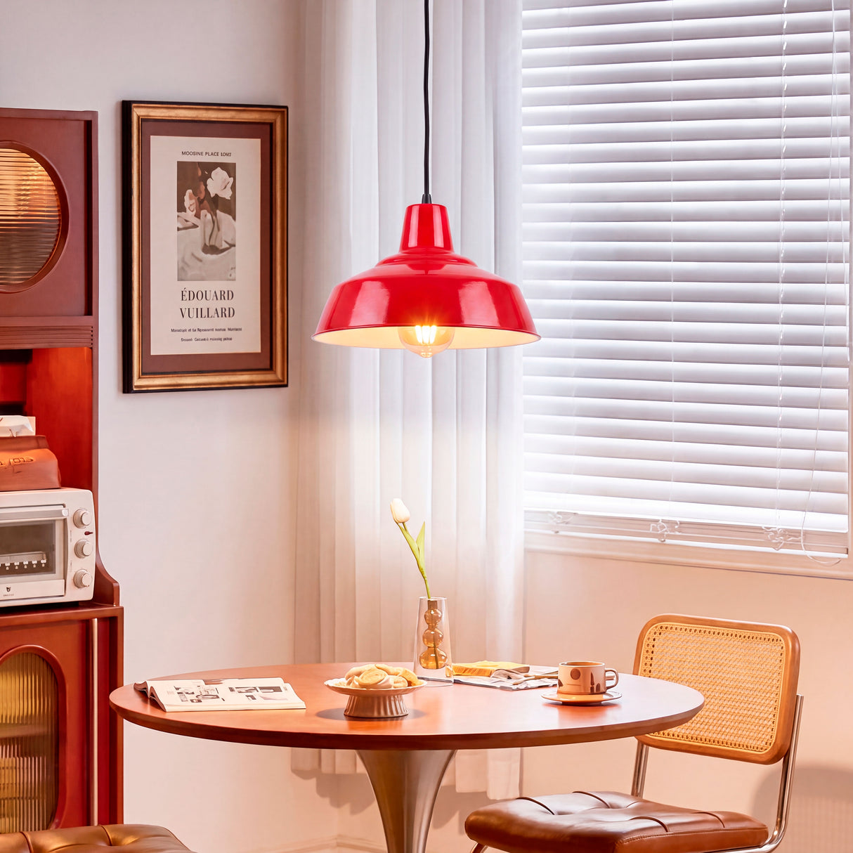 Lámpara colgante roja sobre mesa de madera generando un ambiente acogedor con diseño minimalista.