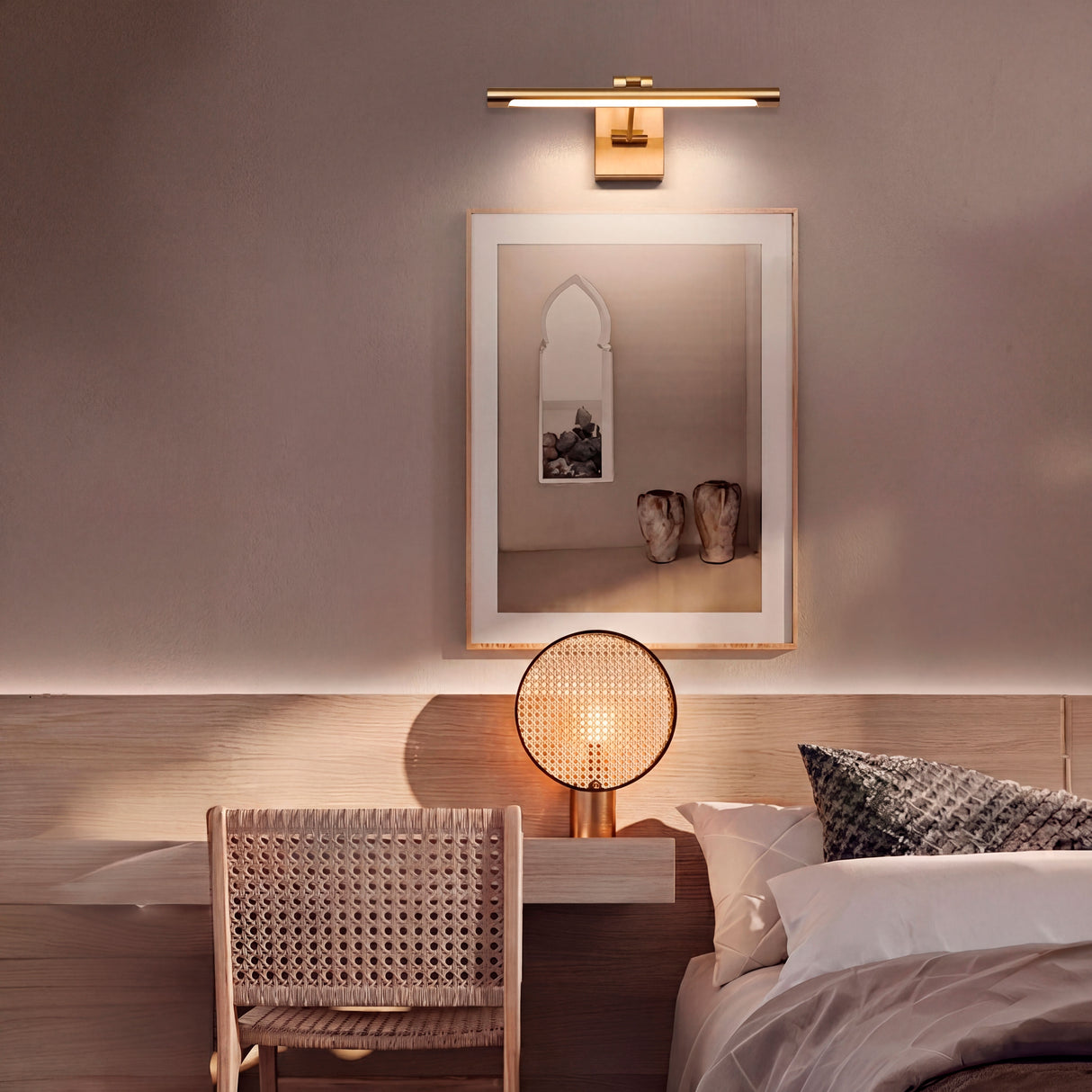 Lámpara Nerina instalada sobre el cabecero de cama para resaltar cuadros decorativos.
