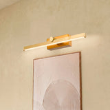 Lámpara de latón instalada sobre cuadro decorativo en baño de diseño rústico-chic.