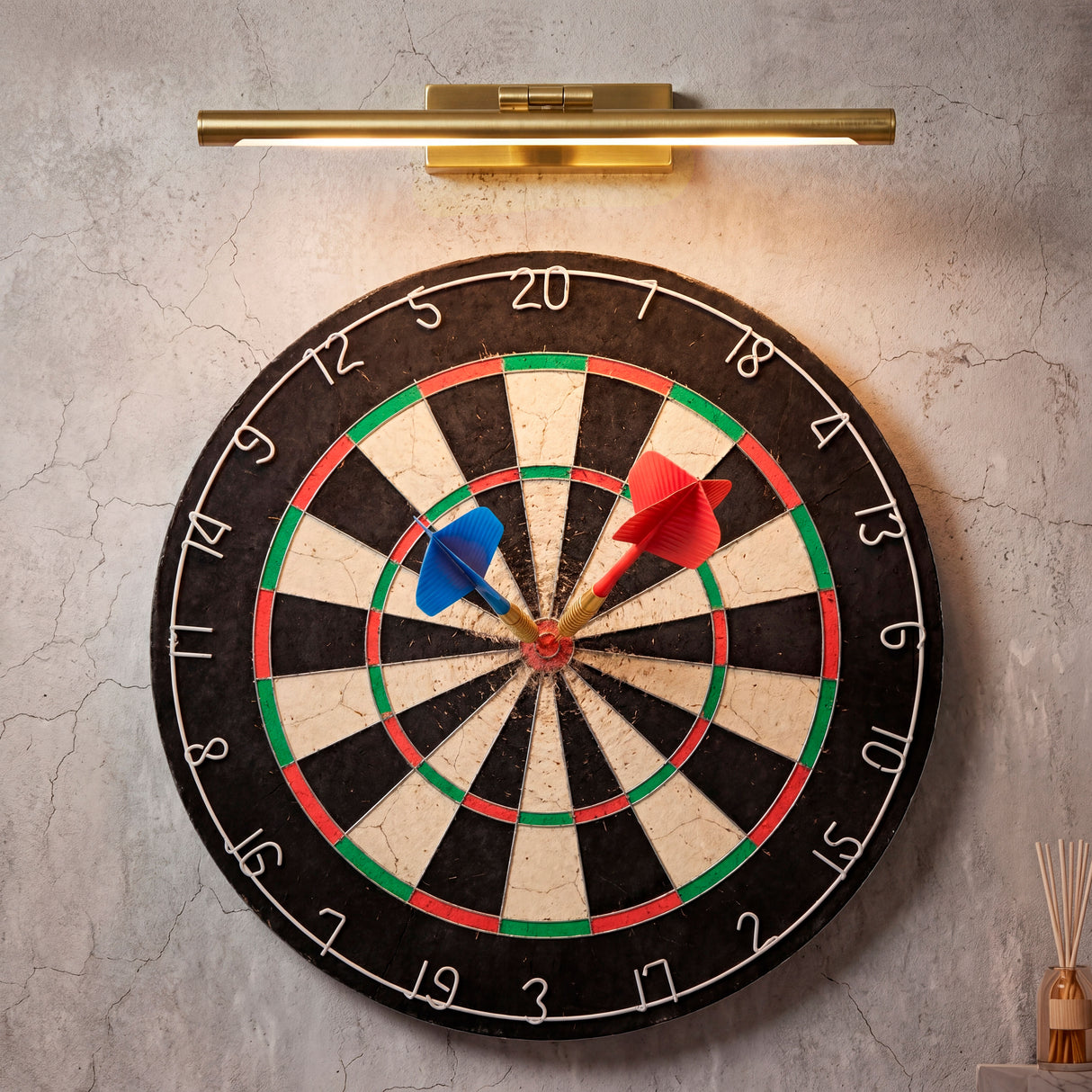Lámpara de pared Nerina iluminando una diana de dardos, ideal para zonas de juegos.