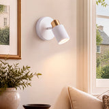 Aplique orientable emitiendo luz de acento cálida en pared residencial para optimizar el confort visual.