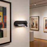 Uso de aplique para destacar obras de arte en espacios de diseño de interiores.