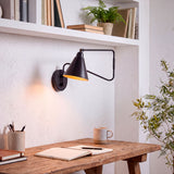 Aplique de extensión de pared sobre mesa de trabajo creando un ambiente funcional y ordenado.