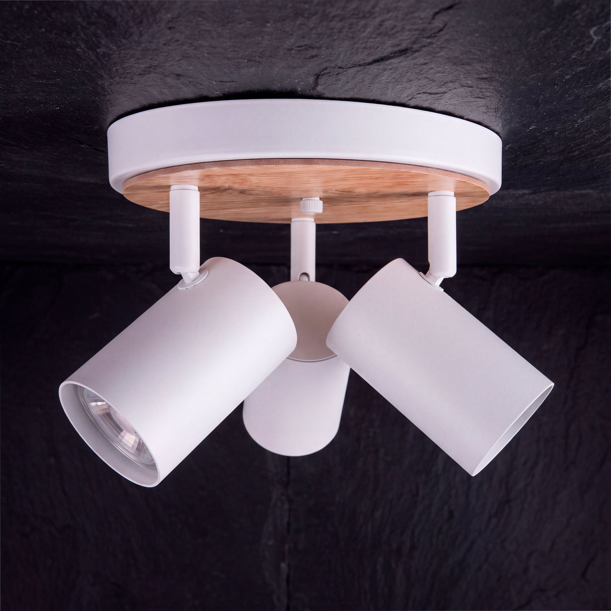 Baño de luz cenital de sobreponer en contraste sobre superficie negra de estilo contemporáneo.
