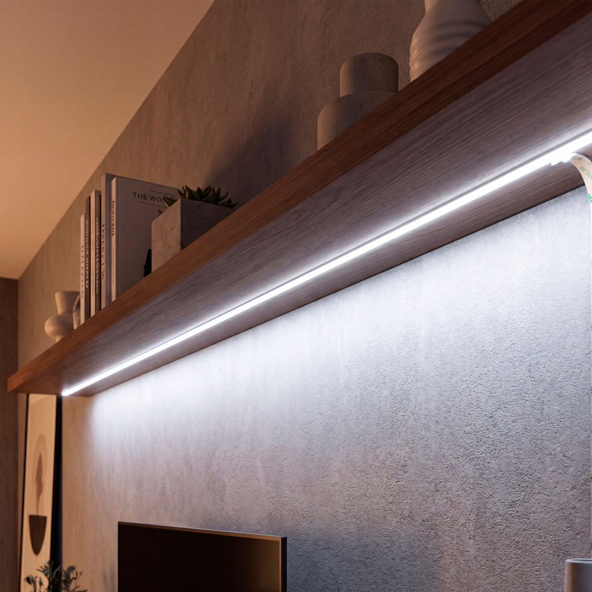 Luz blanca lineal continua oculta debajo de repisa flotante de madera, optimizando el confort visual.