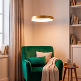 Lámpara Mirabella sobre sillón de lectura verde creando una atmósfera acogedora y moderna.