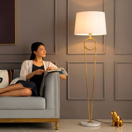 Mujer relajada en el sofá bajo la luz cálida de la lámpara decorativa Olinda Gold.