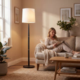 Punto de luz ambiental cálida junto a un sillón para crear confort visual en salas de estar de hoteles.